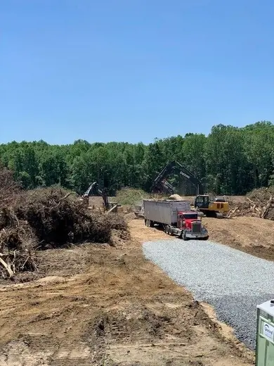 Excavators and a semi truck loading cleared timber on a Hunterdon County land clearing job