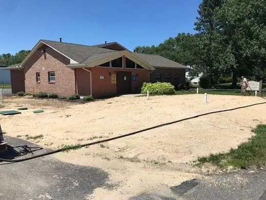 Commercial building lot with bare prepped soil and irrigation hoses run before hydroseeding