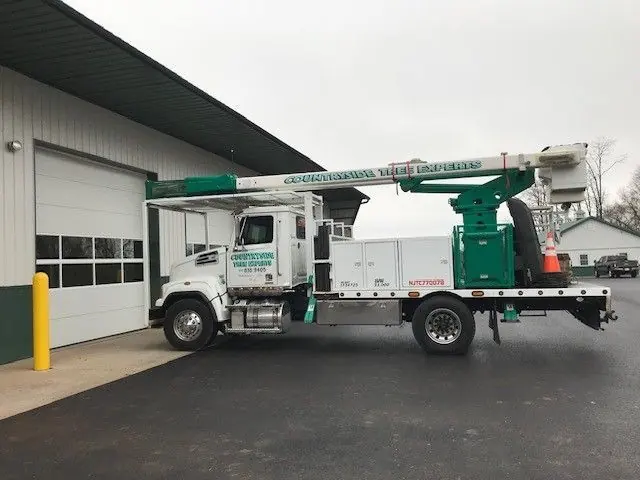 Countryside Tree Experts bucket truck parked at the company yard, company name legible along the boom