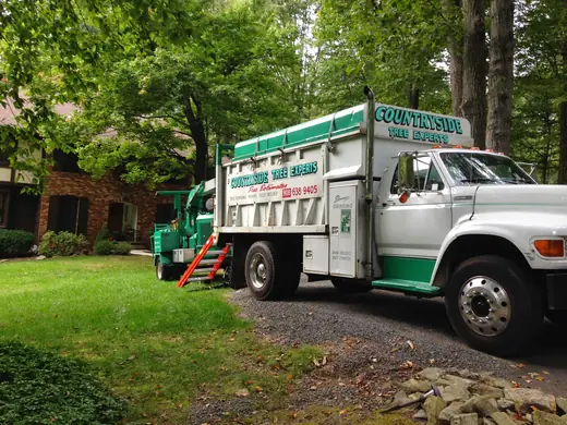 Countryside Tree Experts chipper truck with the ISA Certified Arborist On Staff emblem, stump grinding and free estimates lettering on the door